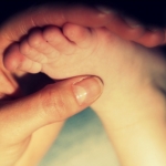pied bébé dans main maman