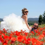 Photo de mariés dans champs de coquelicots